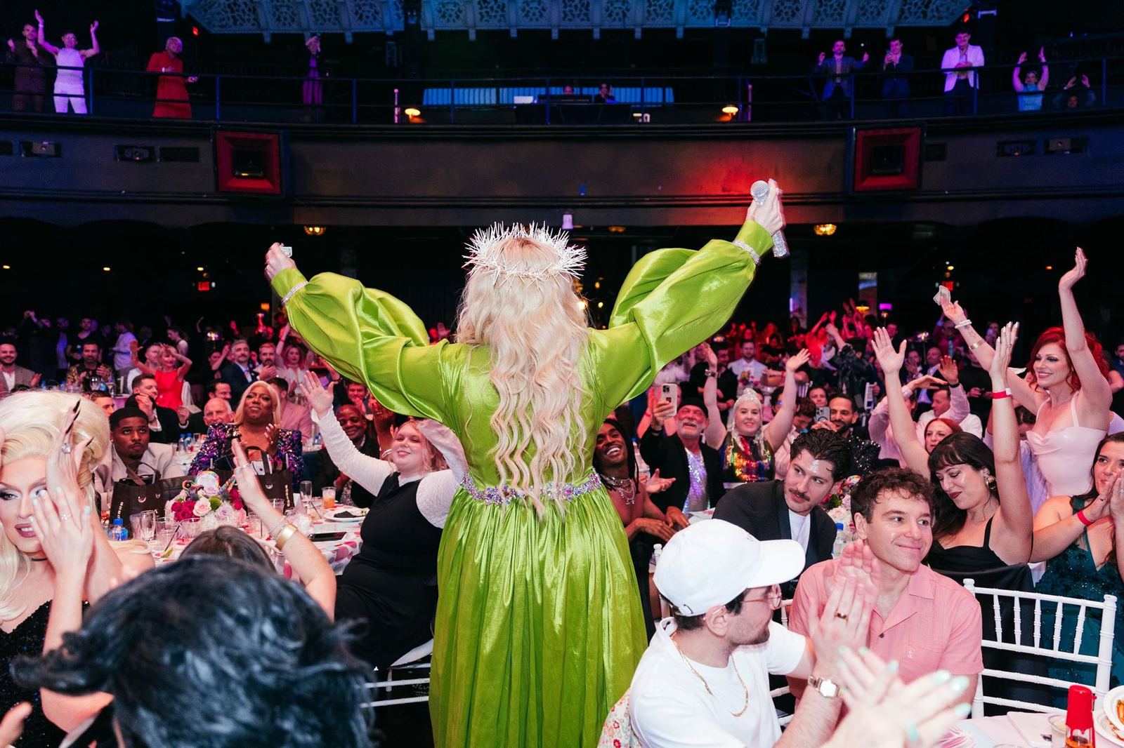 The whole room on its feet, arms up, at the LA Gayla