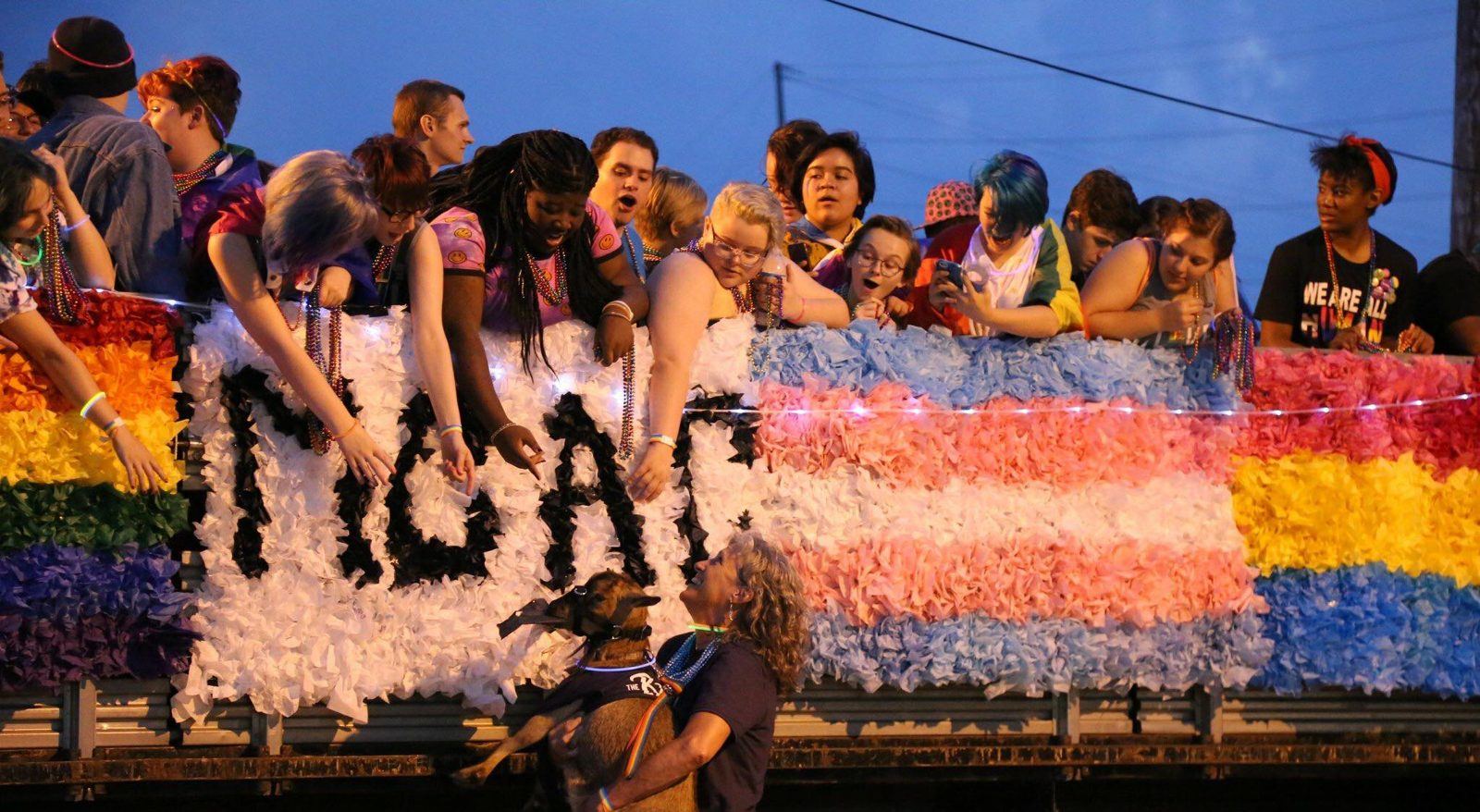 Youth from Magic City Acceptance Center ride a pride float covered in rainbow and trans flag colors